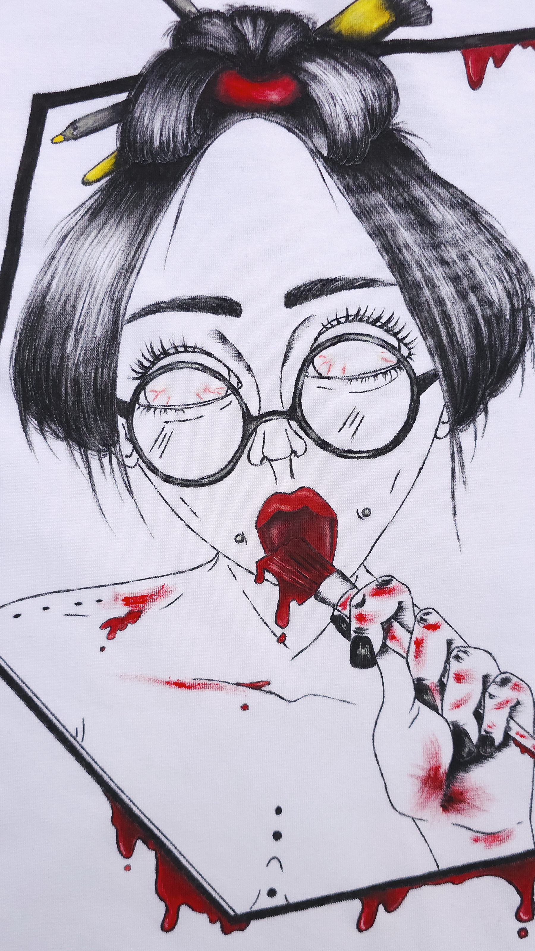 White t-shirt with a graphic design. The design is hand painted and shows a girl with round glasses, red paint dripping and a brush. This is a close up.