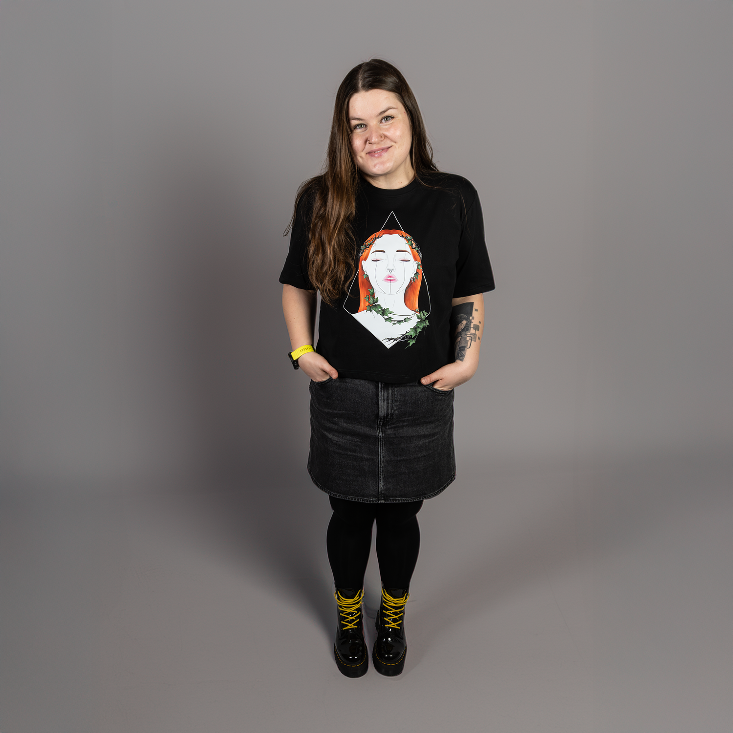 Person wearing a black t-shirt with a graphic design on a gray background