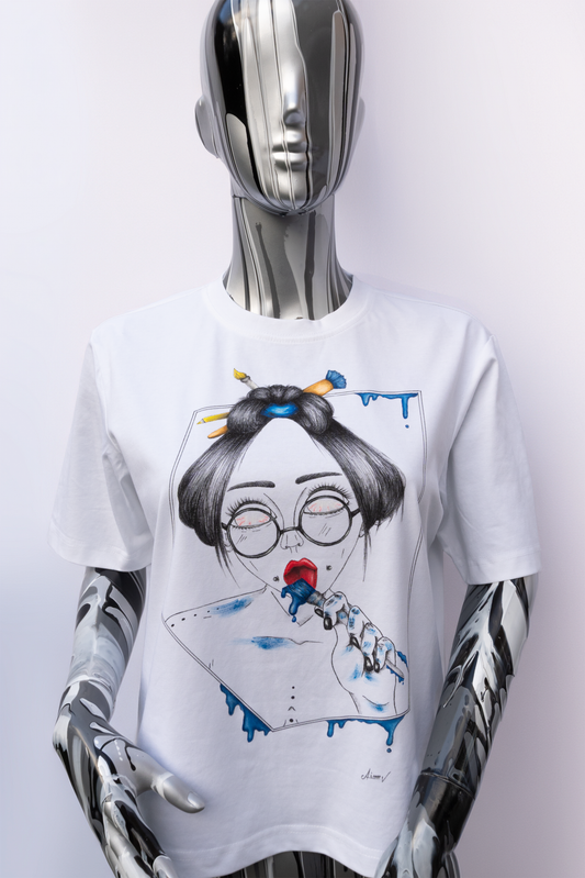 Mannequin wearing a white t-shirt with a graphic design on a plain background. The design is hand painted and shows a girl with round glasses, blue paint dripping and a brush.