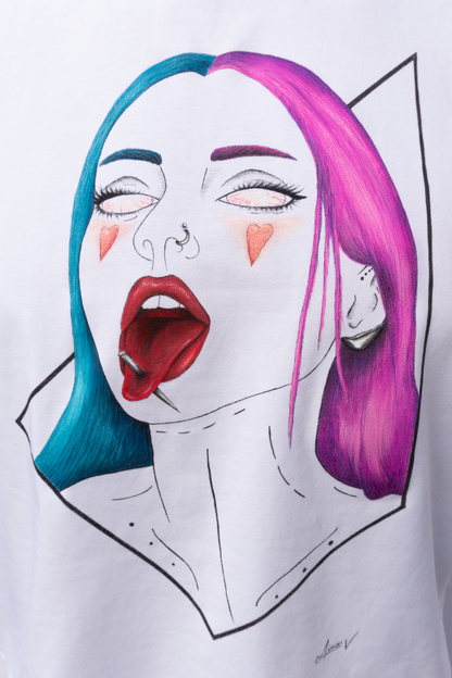 White t-shirt with a graphic design. The design is hand painted and shows a girl with blue and pink hair, a needle through the tongue and a geometrical frame.